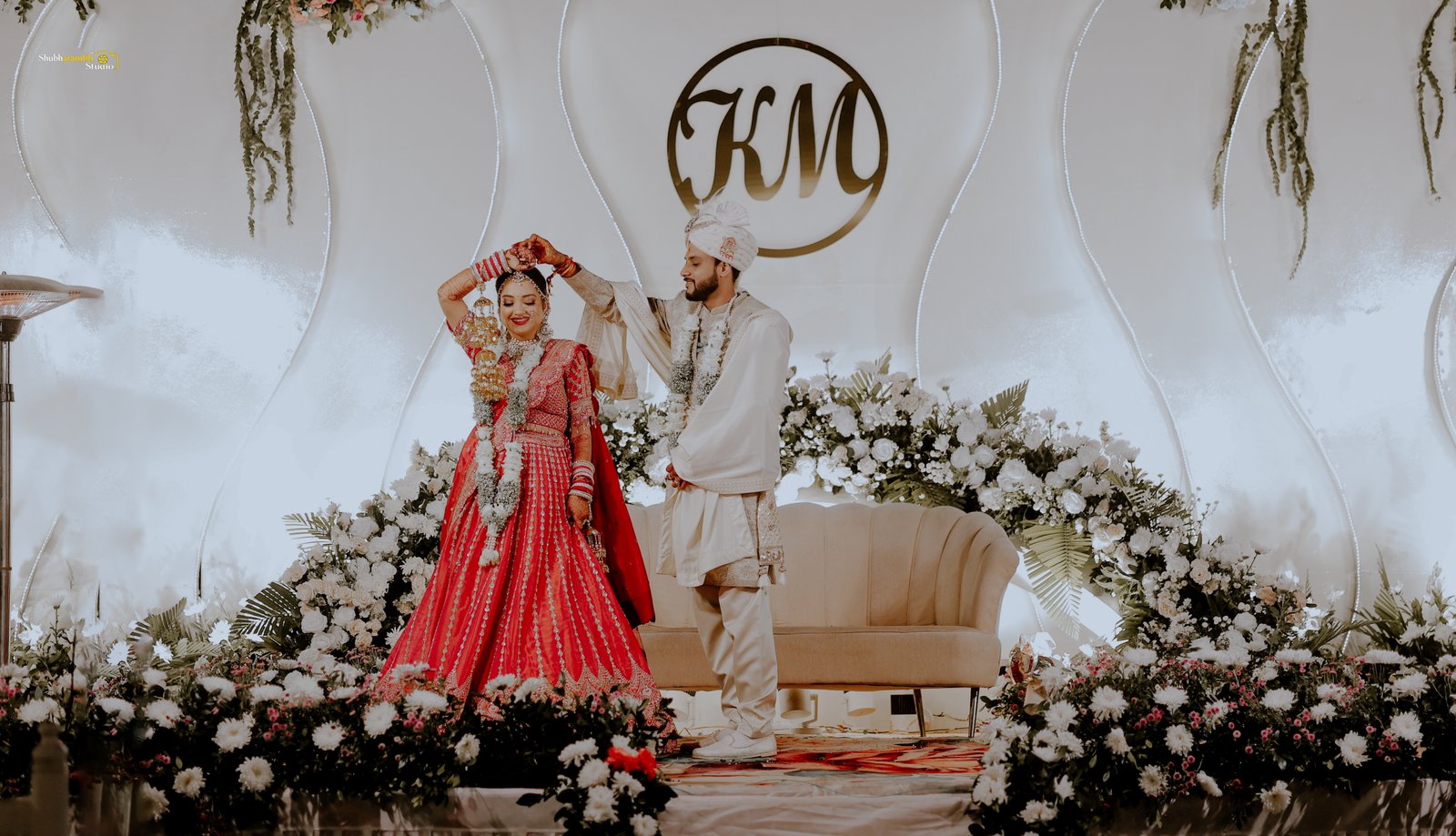 Bride reaching toward a crystal chandelier, laughing