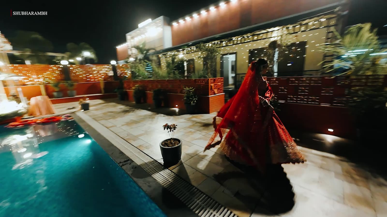 Bride walking a lantern-lit poolside at night — film poster